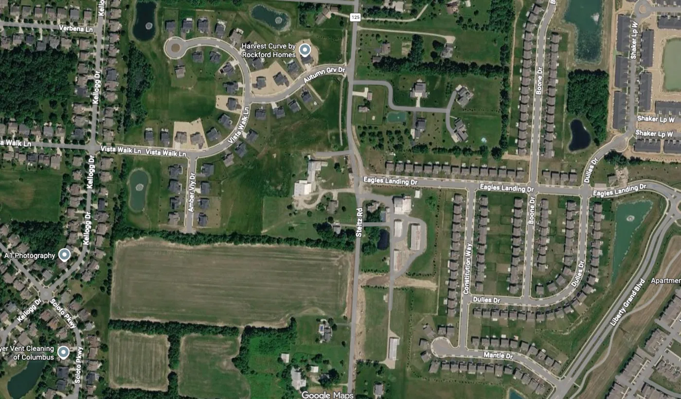 A quiet suburban Ohio road curving through a neighborhood at sunrise